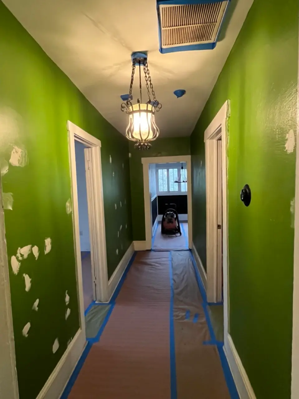 Hallway before painting: green walls with spackle patches