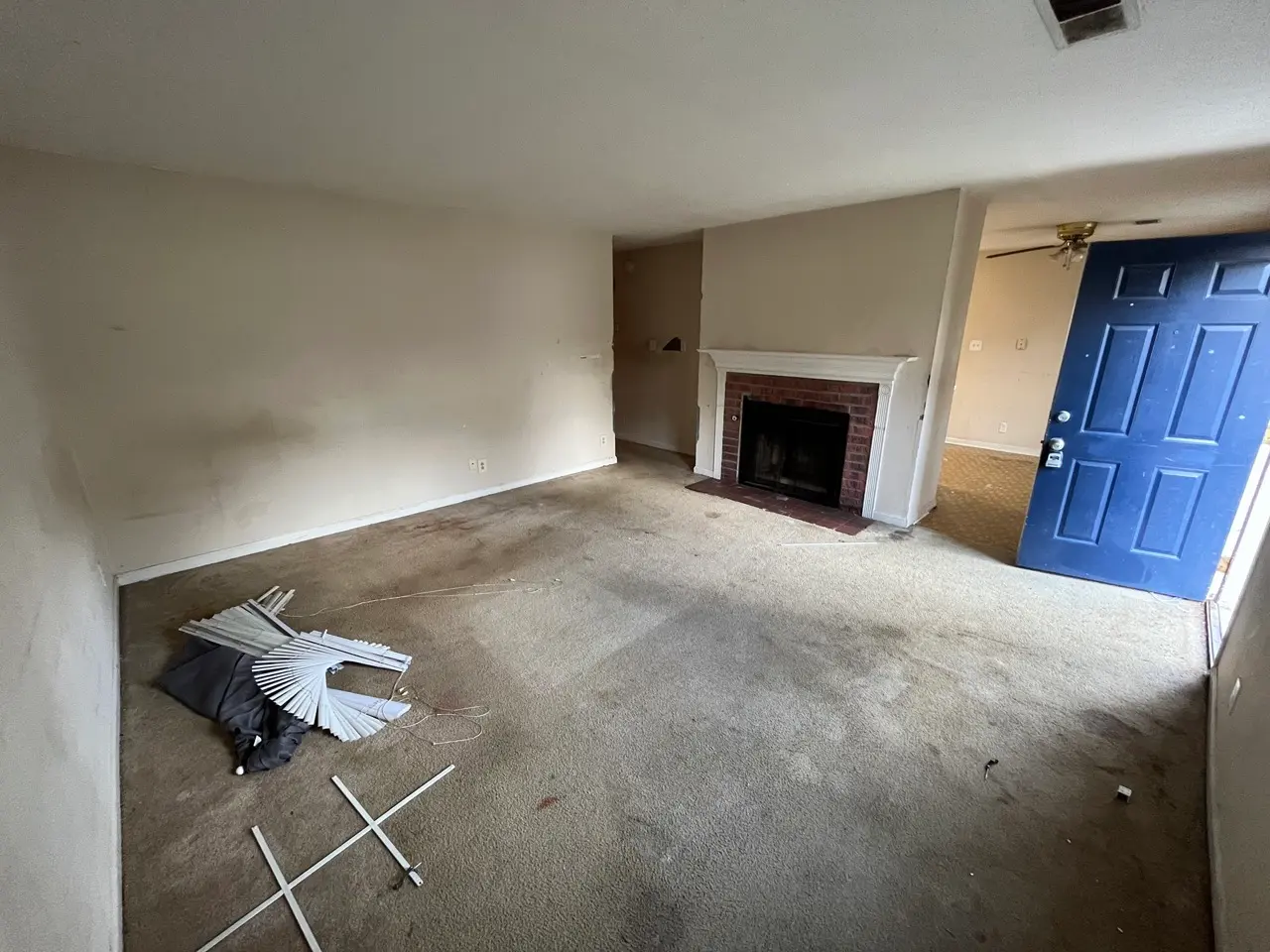 Living room before painting: dingy walls with debris on the floor